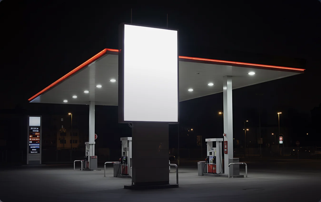 Petrol station canopy at night with an illuminated digital display pillar